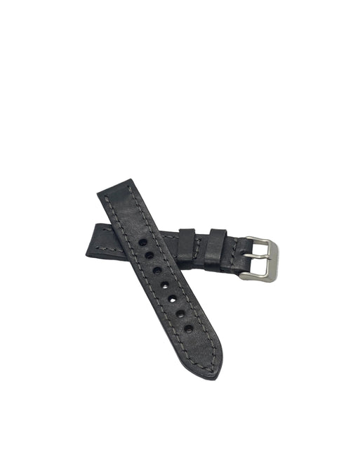 A black badalassi carlo italian leather watch strap with silver-toned hardware, laid on a textured white surface.